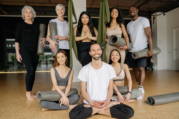 Diverse group of people smiling during a yoga class.
